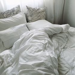Crumpled white sheet on bed at home