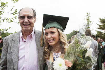 Young woman with father at graduation ceremony