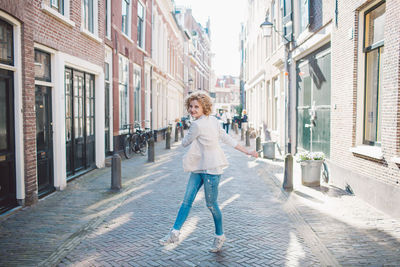 Cheerful woman walking on street in city