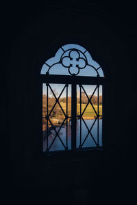 Silhouette built structure against sky seen through window