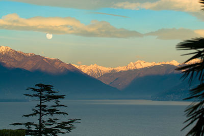 Scenic view of lake and mountains against sky during sunset