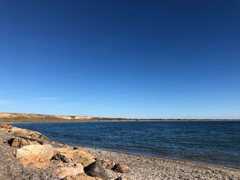 Scenic view of sea against clear blue sky