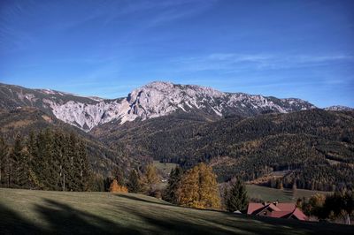 Scenic view of mountains against blue sky