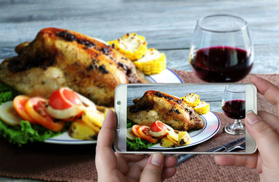 Close-up of hand holding food served on table