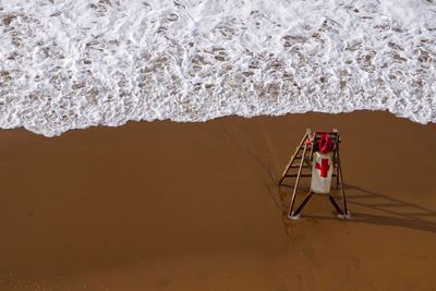 High angle view of lifeguard chair on shore at beach