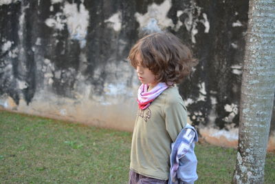 Boy removing jacket while standing on field