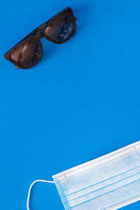 Low angle view of sunglasses against blue sky