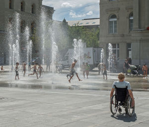 People playing in city fountain