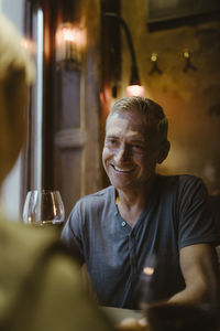 Smiling man talking to woman while sitting during date at restaurant