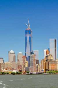 View of buildings in city against clear blue sky