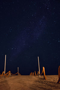 Ropes at sandy beach against star field