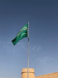 Low angle view of flags against blue sky