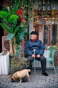 Man holding dog against plants