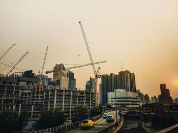 Construction site by buildings against clear sky