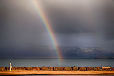 Scenic view of rainbow over mountain against sky