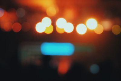 Defocused image of illuminated city against sky at night