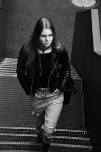 High angle view of young woman moving up on steps