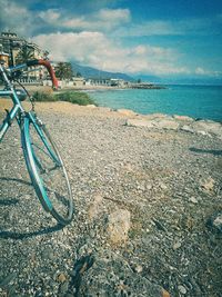 Bicycle on beach against sky