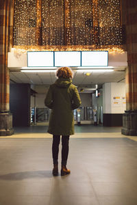 Rear view of woman looking at illuminated board