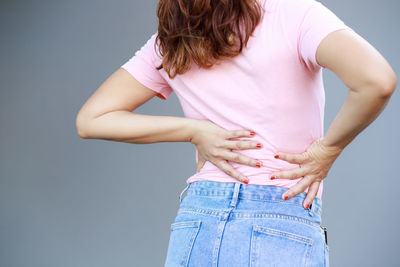 Midsection of woman standing against wall