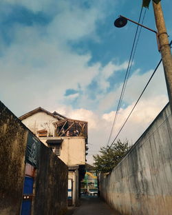 Low angle view of street amidst buildings against sky