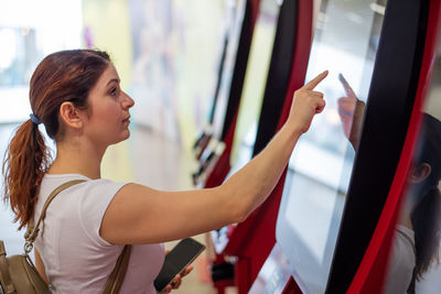 Side view of woman using atm machine