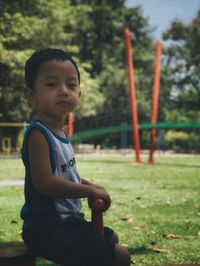 Portrait of cute boy sitting in park