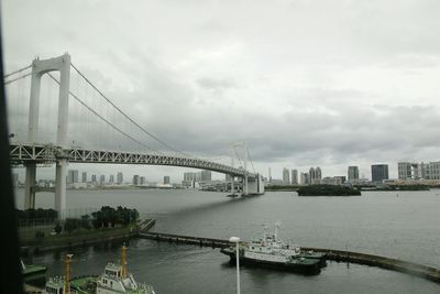 View of suspension bridge against cloudy sky