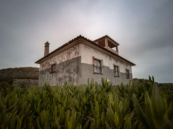 Abandoned house on field against sky