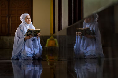 Full length of woman reading book