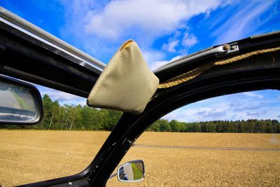 Car on field by road against sky