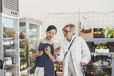 Female owner showing product to customer while buying in store