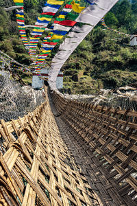 Ancient holy bamboo bridge with many buddhist holy flags from unique perspective