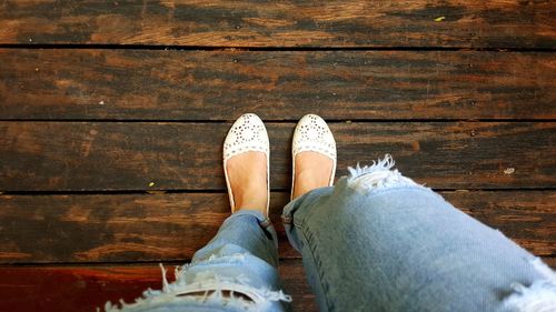 Low section of woman standing on hardwood floor