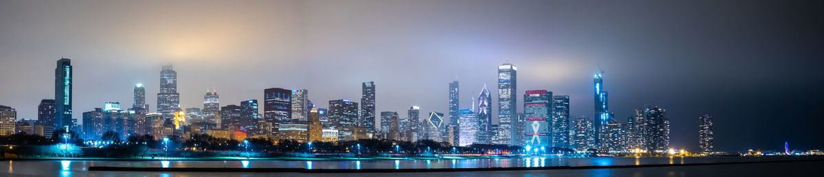 Panoramic view of illuminated buildings against sky at night