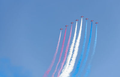 Low angle view of airshow against blue sky