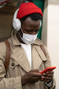 Midsection of man holding mobile phone