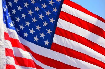 Close-up of american flag against blue sky