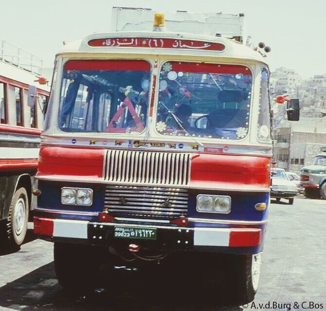 transportation, mode of transport, land vehicle, car, red, bus, travel, street, public transportation, stationary, building exterior, day, architecture, train - vehicle, built structure, city, window, incidental people, road, passenger train