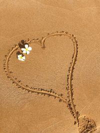 High angle view of heart shape on sand at beach