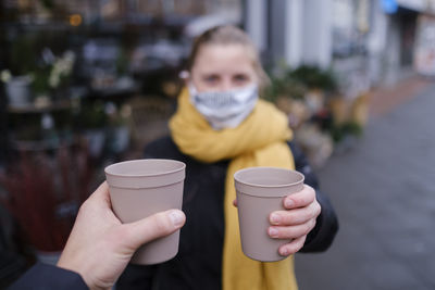 Midsection of woman holding coffee cup