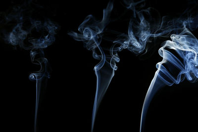 Close-up of emitting smoke against black background