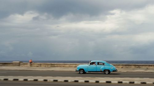 Car on beach against sky