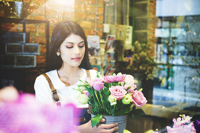 Woman adjusting flowers at shop