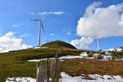 Windmill on field against sky