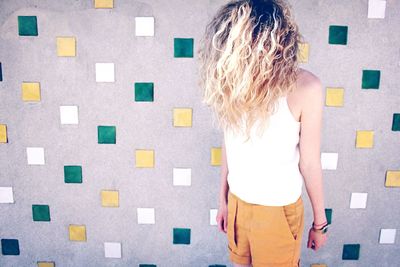 Fashion model standing against patterned wall
