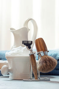 Close-up of shaving equipment on table