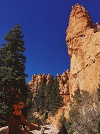 Low angle view of rock formation against clear blue sky