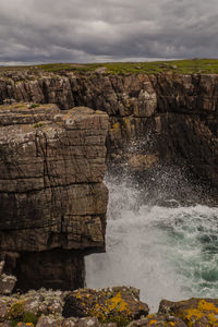 Rock formations by sea against sky