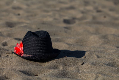 Close-up of black hat on sandy beach